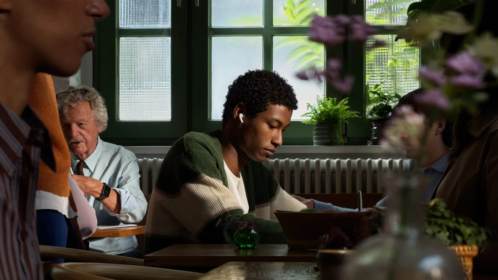 AirPods 5 user working in a busy space