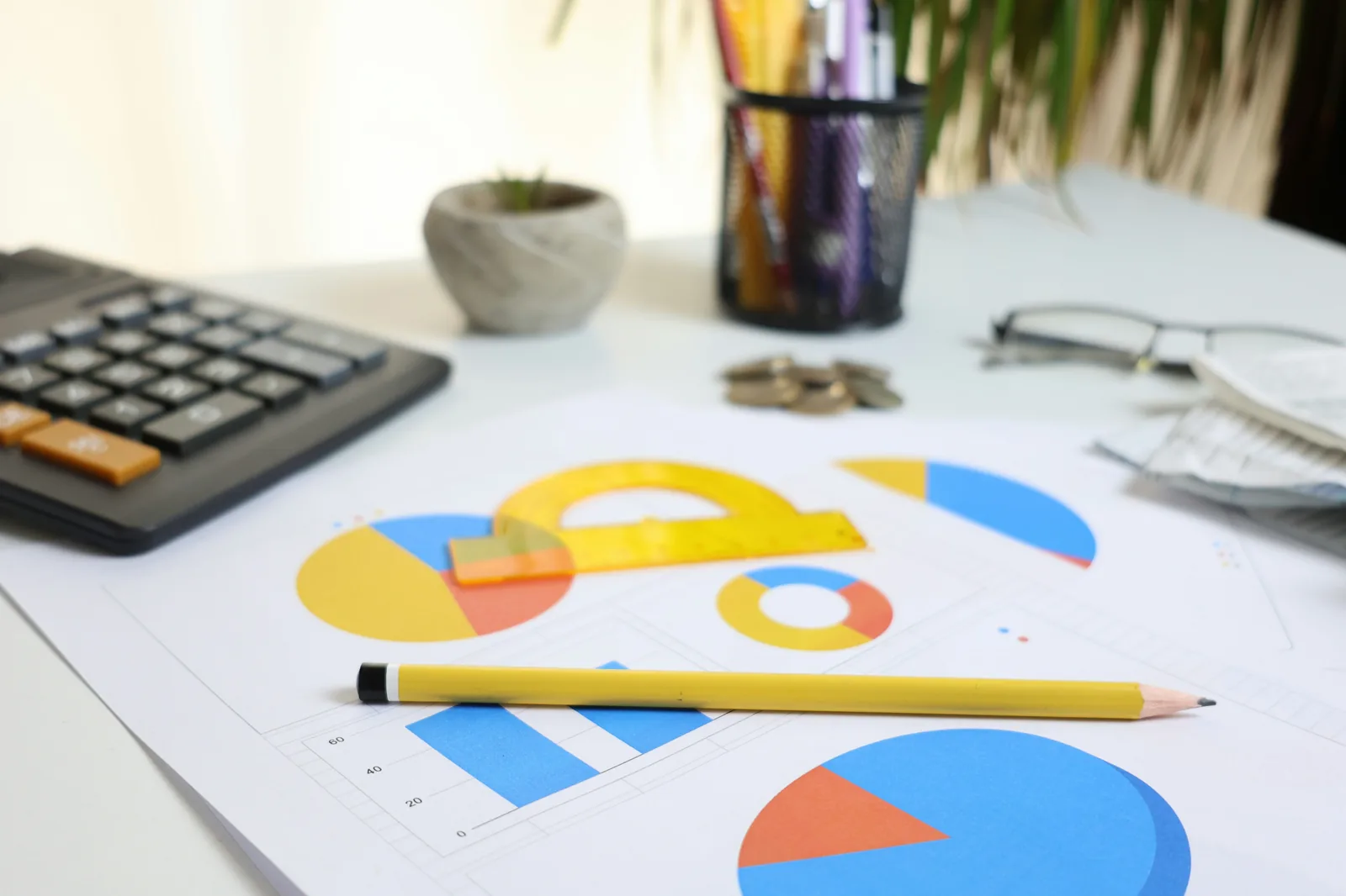 Financial charts, calculator and coins on a desk